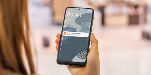 A smartphone held by a woman, showing a mobile-pocket ad push notification on the lock screen.