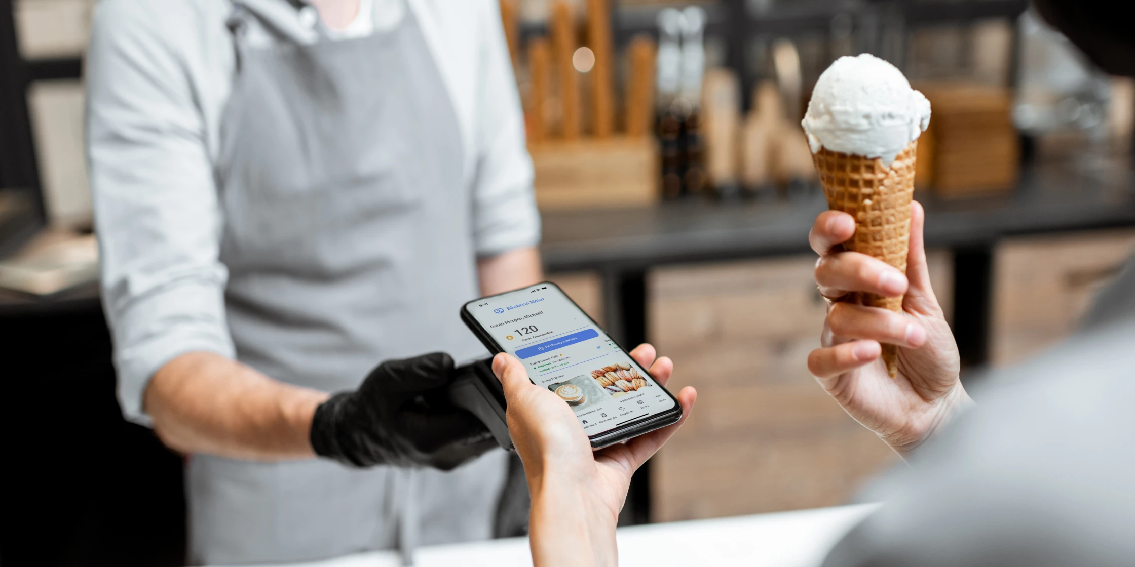 Digitale Kundenbindung im Handel: Kunde kauft Eis und nutzt Loyalty Software am Smartphone